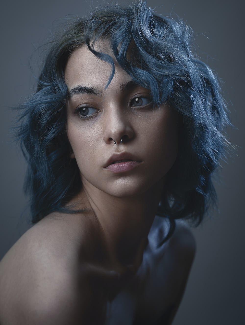 a woman with blue hair is posing for a picture
