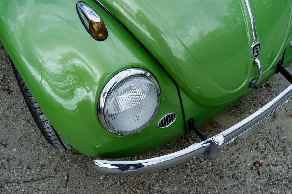 a close up of the front end of a green vw bug