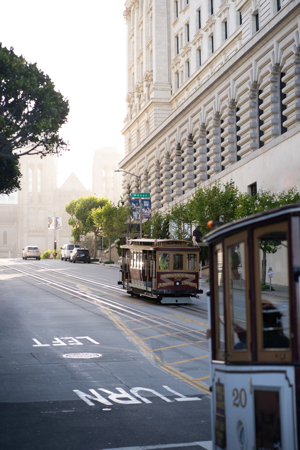 a trolley car driving down a street next to tall buildings