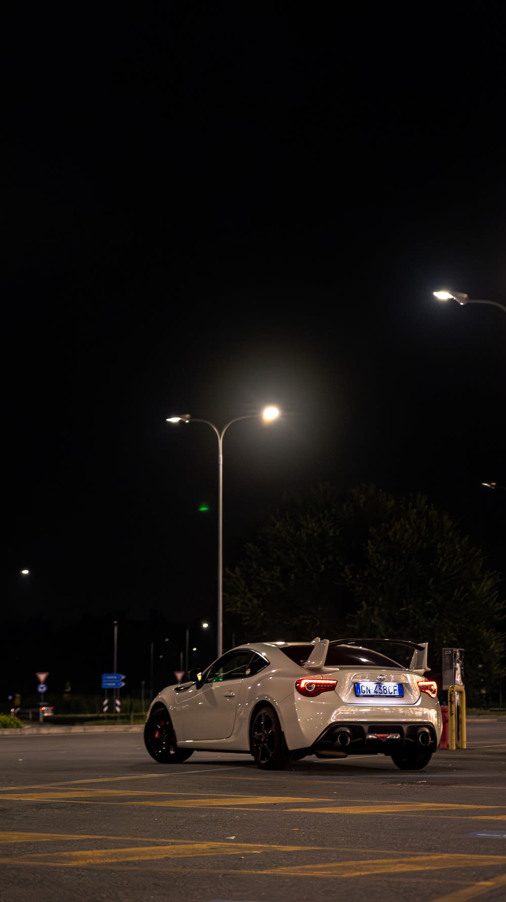 a white sports car parked in a parking lot at night