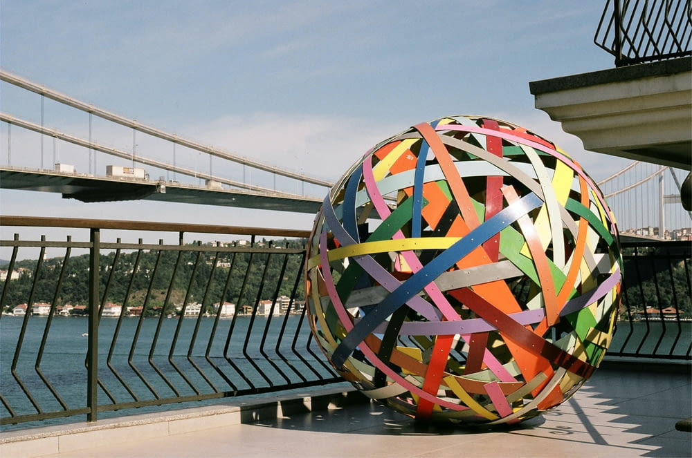 a large colorful ball sitting on top of a sidewalk