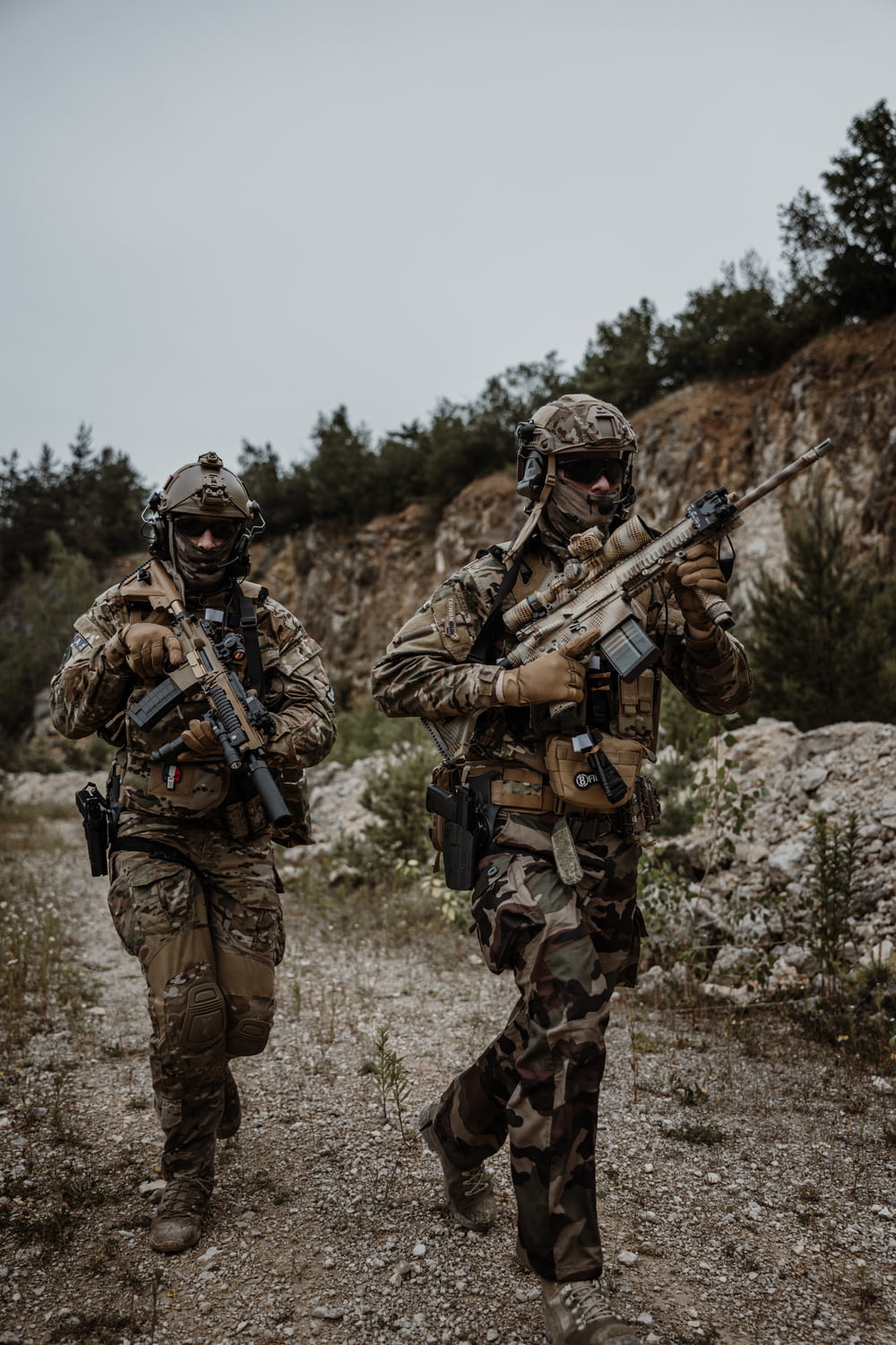a couple of soldiers walking down a dirt road