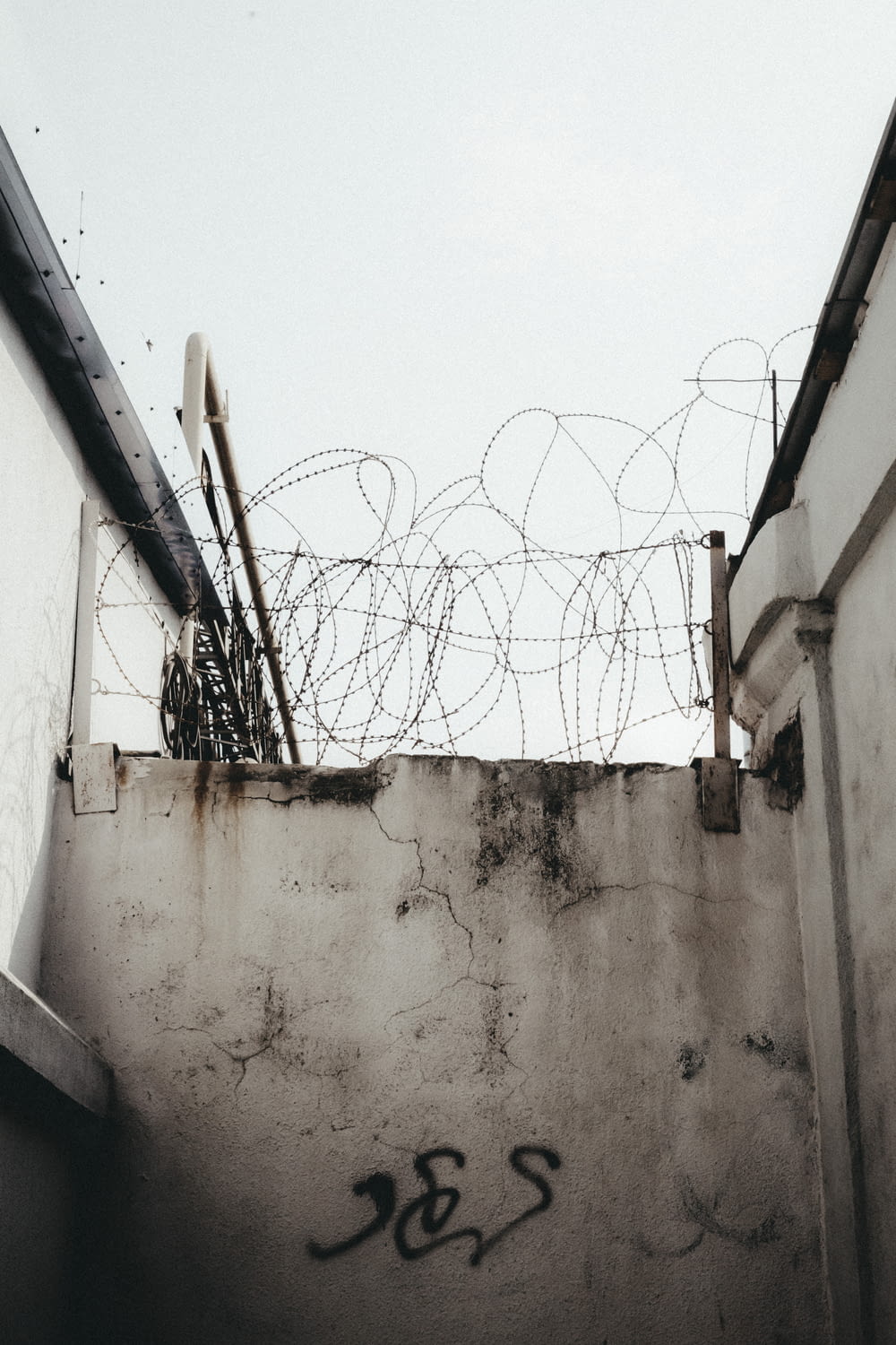 a wall with a bunch of barbed wire on top of it