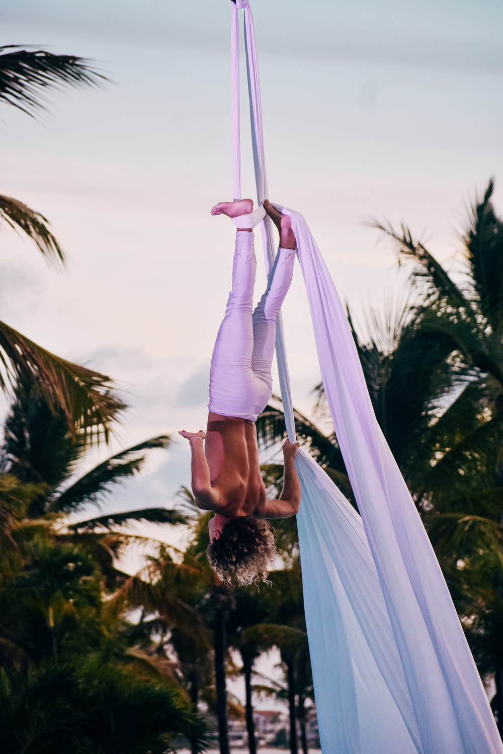 a woman doing aerial acrobatic tricks on a pole