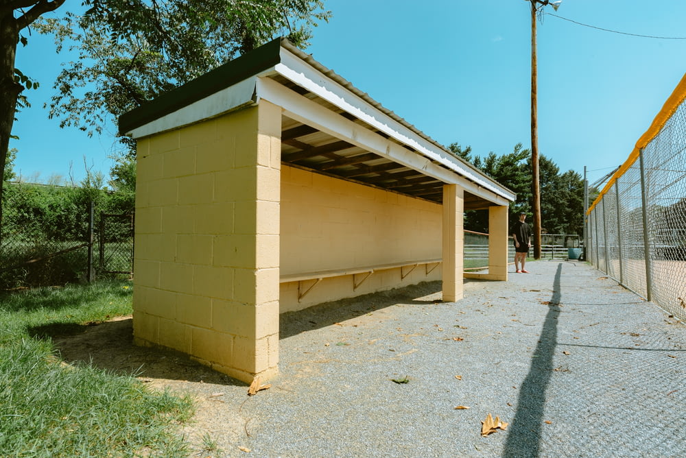 a yellow shelter sitting next to a chain link fence