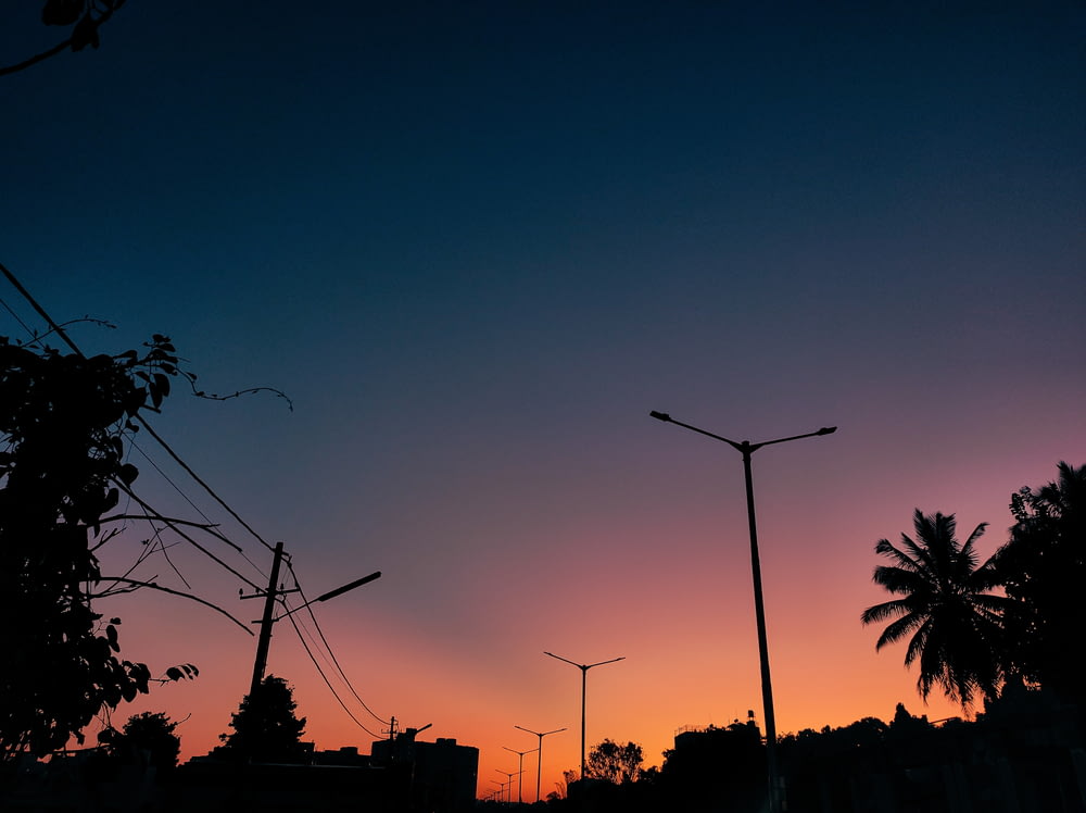 the sun is setting over a city with palm trees
