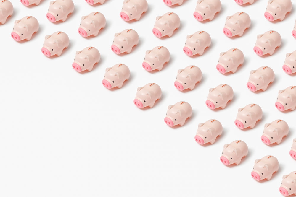 a group of small pink pig figurines on a white surface