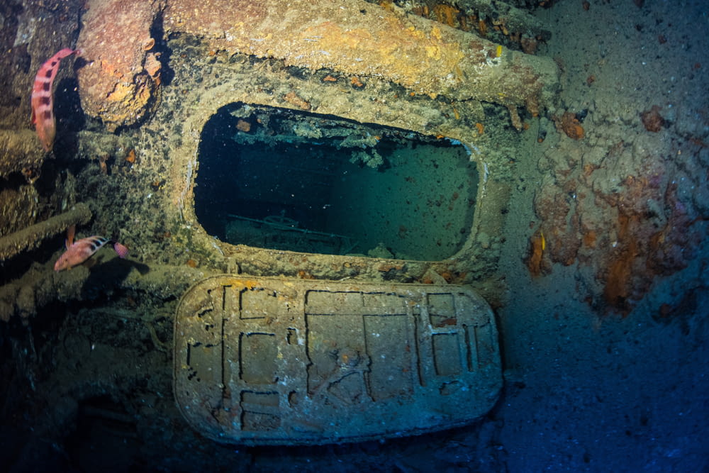 an underwater view of a submarine with a hole in the wall