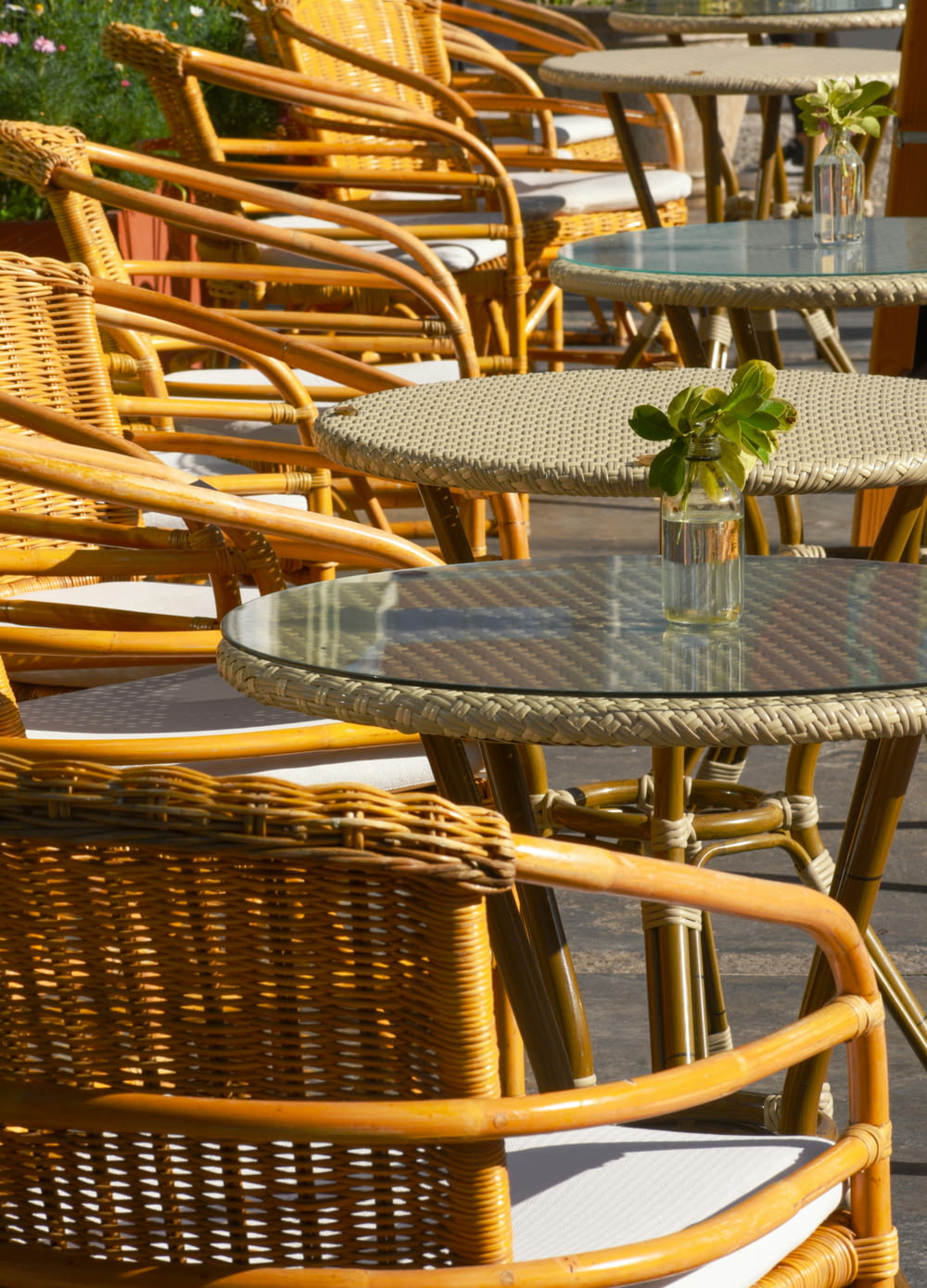 a row of wicker chairs and tables on a patio