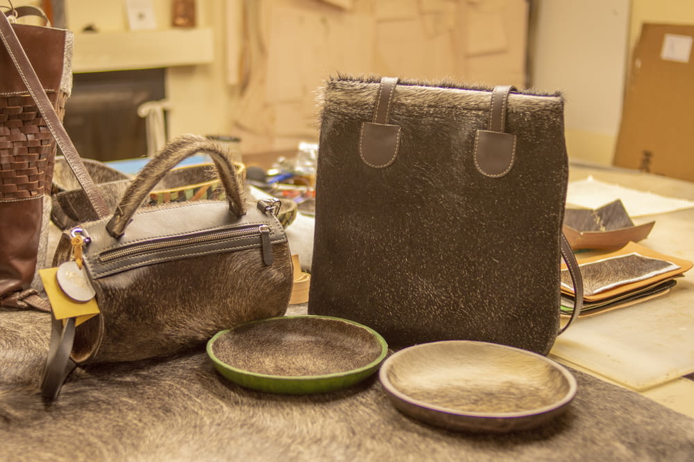 two purses and a bowl on a table