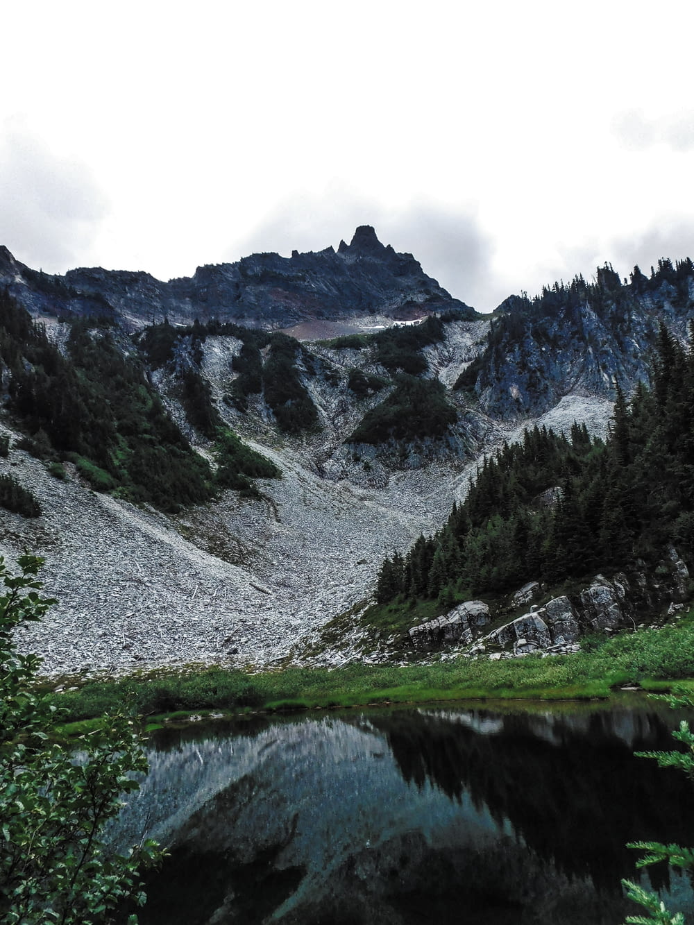 Une chaîne de montagnes avec un lac au premier plan