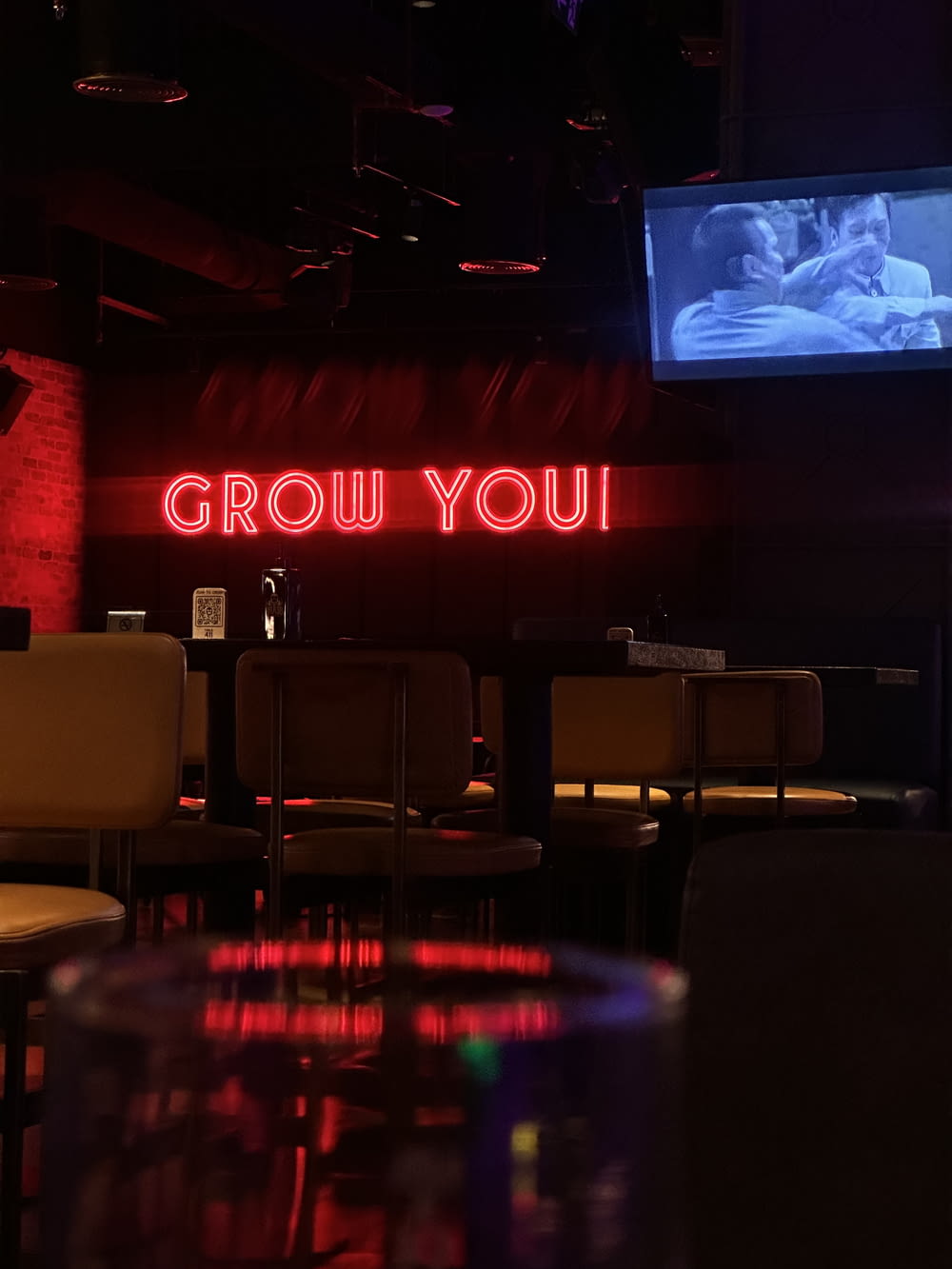 a neon sign that says grow you on a wall