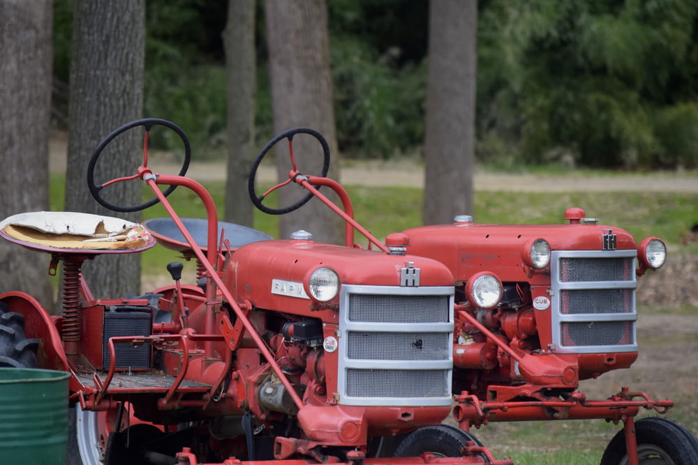 Ein alter roter Traktor, der auf einem Feld geparkt ist