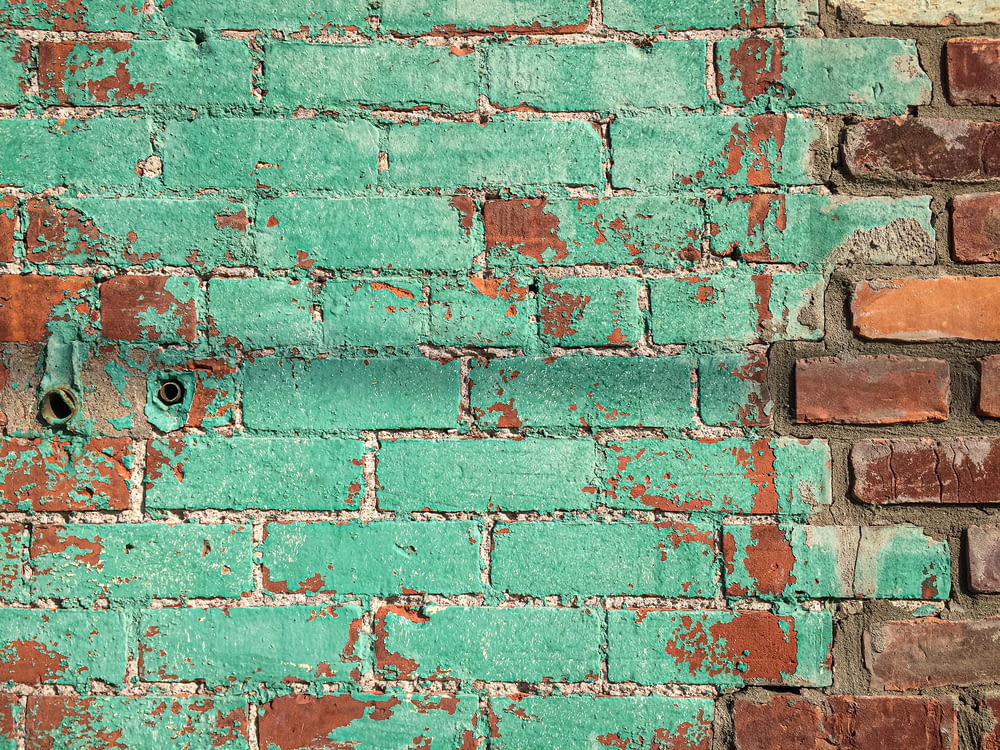 a green brick wall with a hole in it