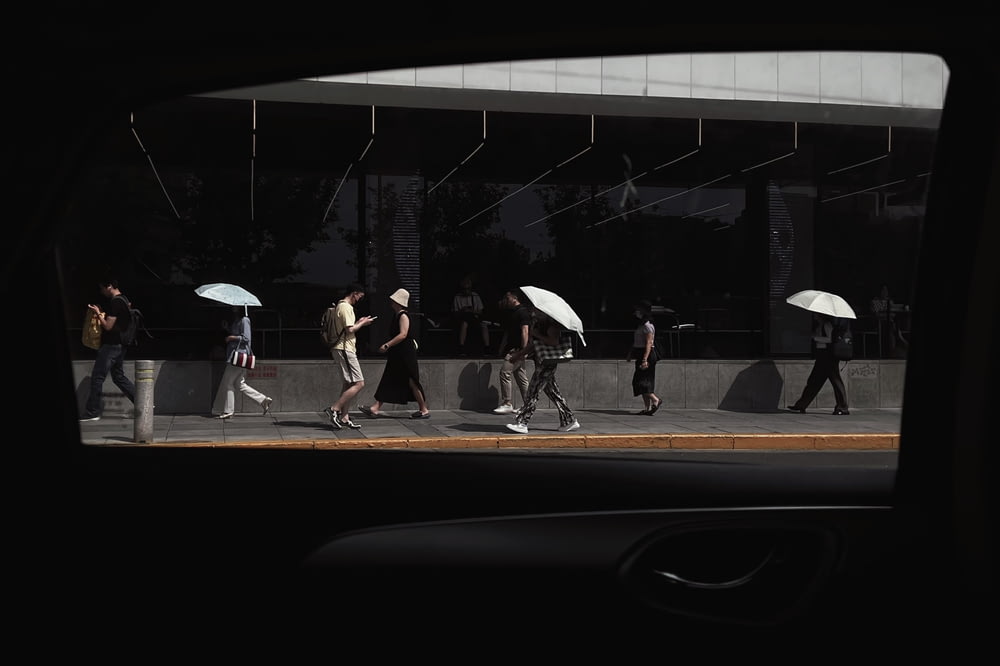 a group of people walking down a street holding umbrellas