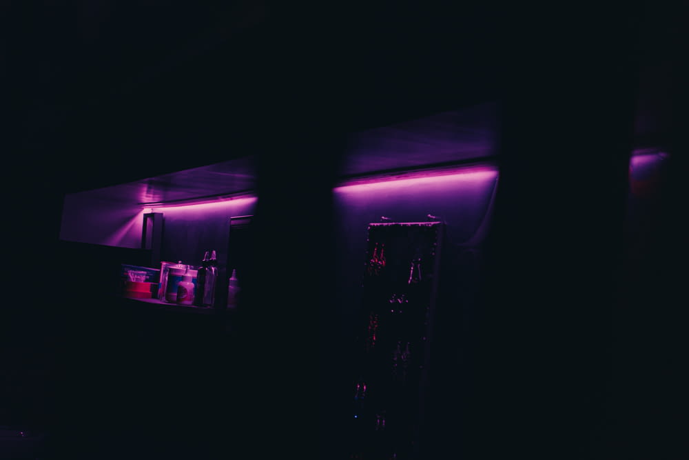 a dark room with a purple light on the wall