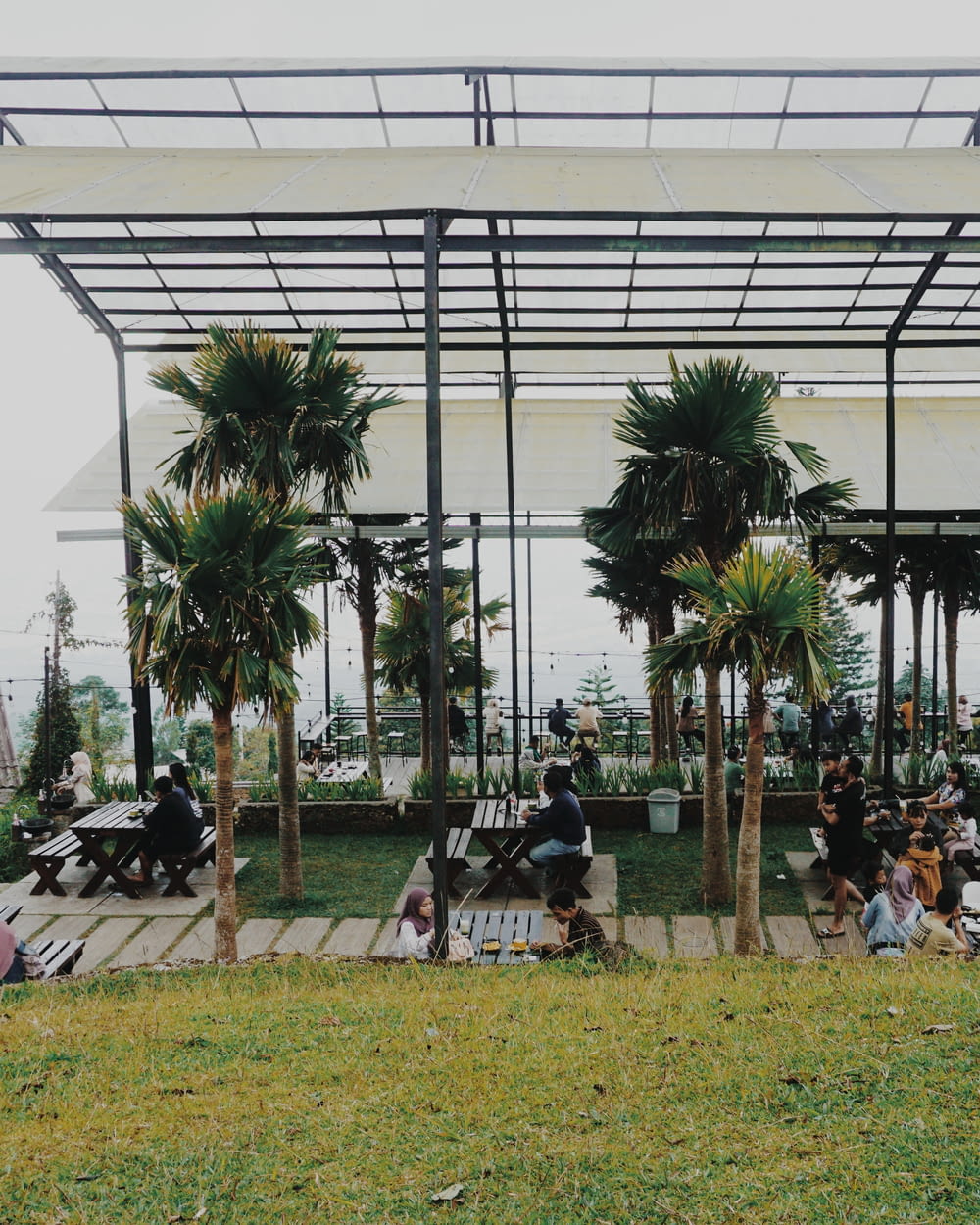 a group of people sitting on benches under a canopy