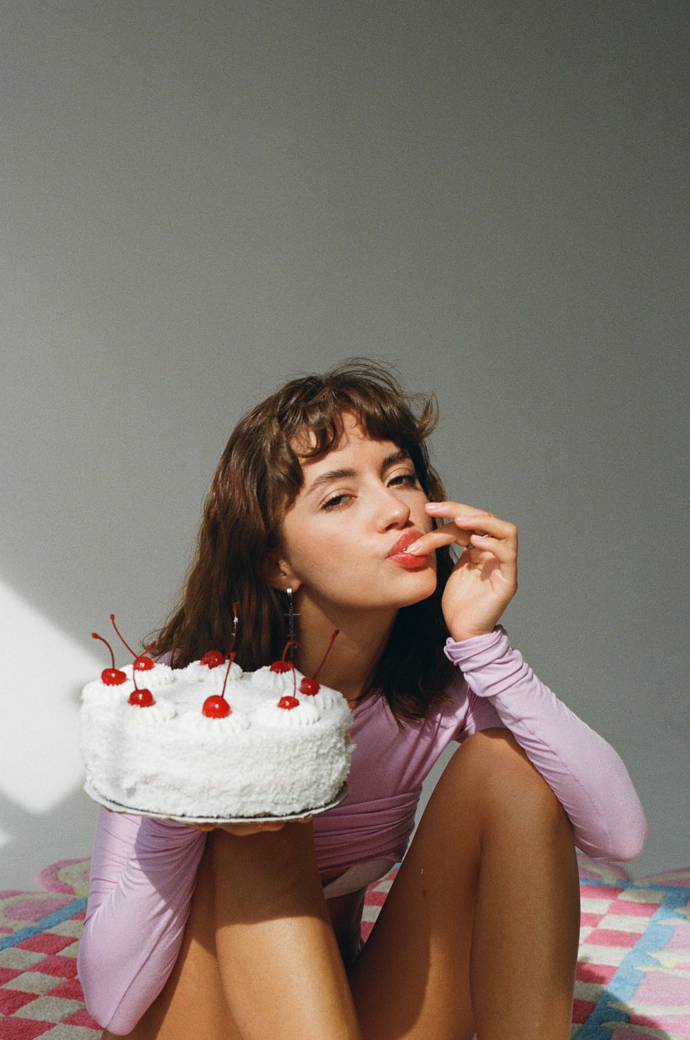 a woman sitting on the floor with a cake