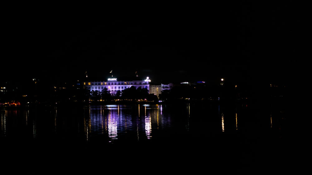 a large building sitting on top of a lake at night