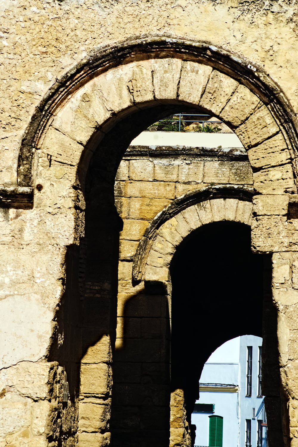 un arco en un edificio de piedra con una puerta blanca