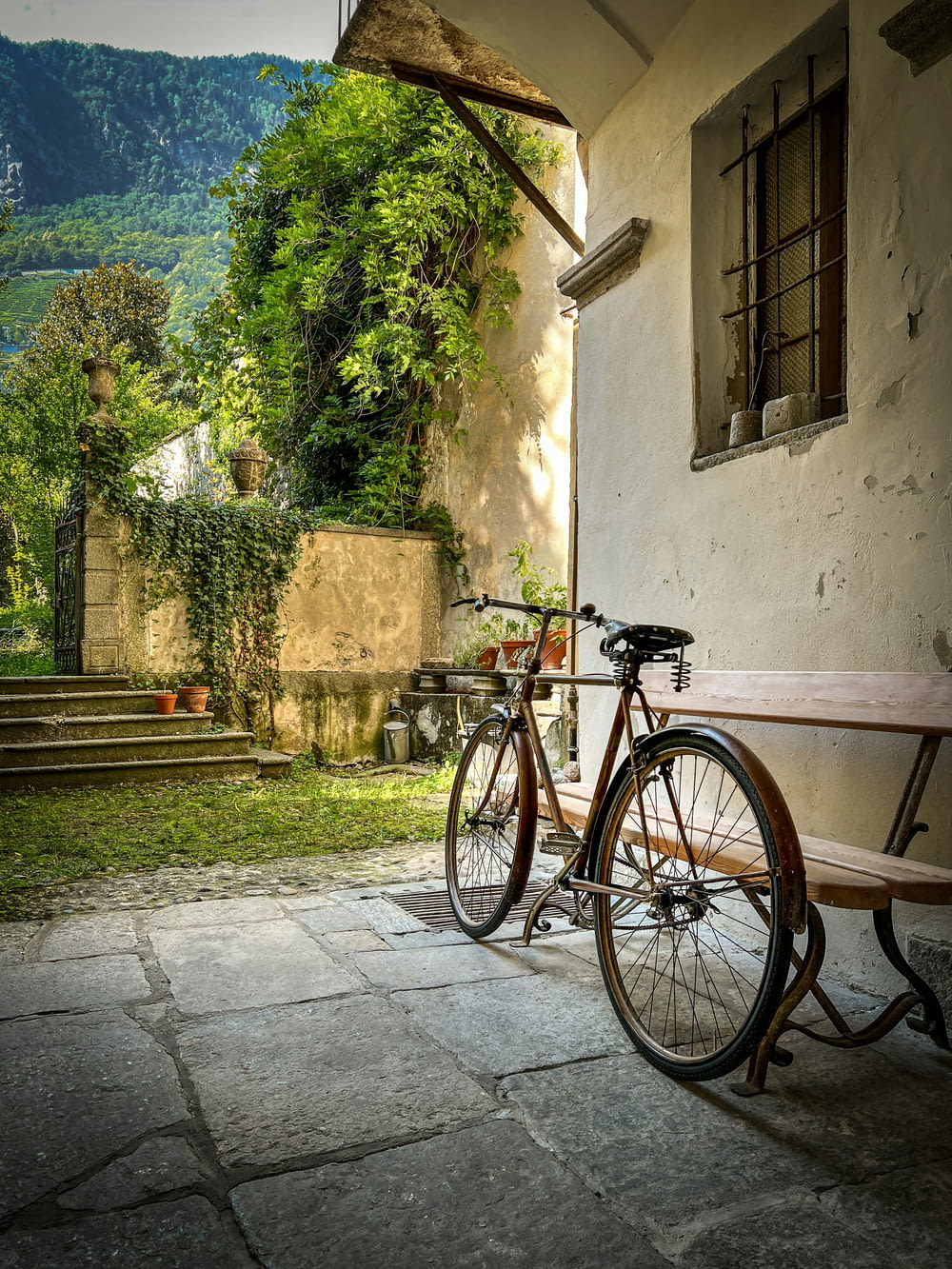a bicycle parked next to a wooden bench