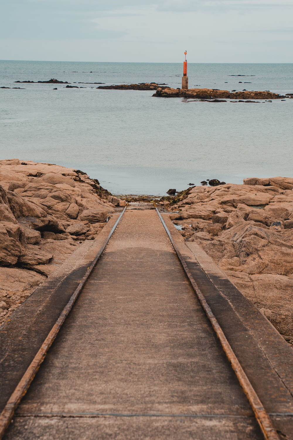 a train track leading to a lighthouse in the ocean