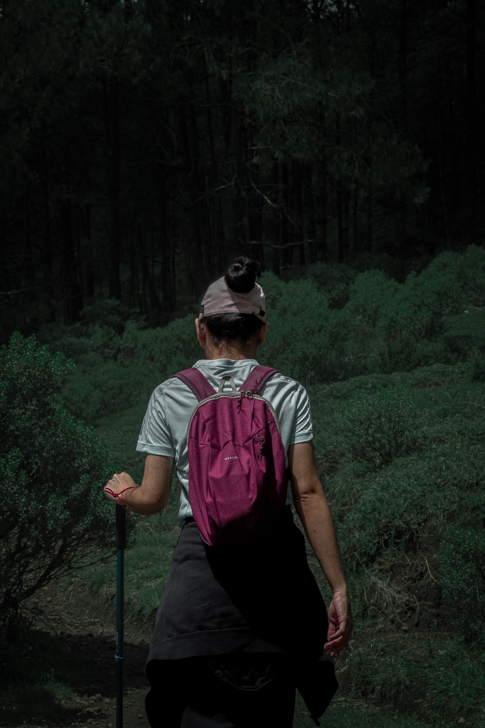 a woman with a backpack walking through a forest