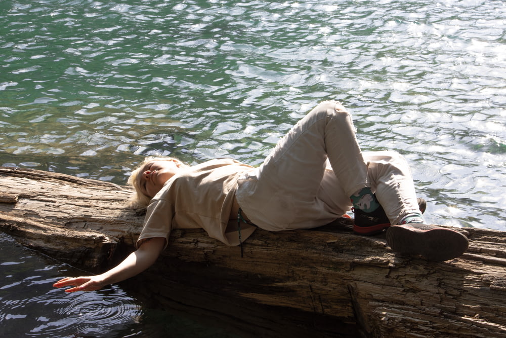 a person laying on a log in the water