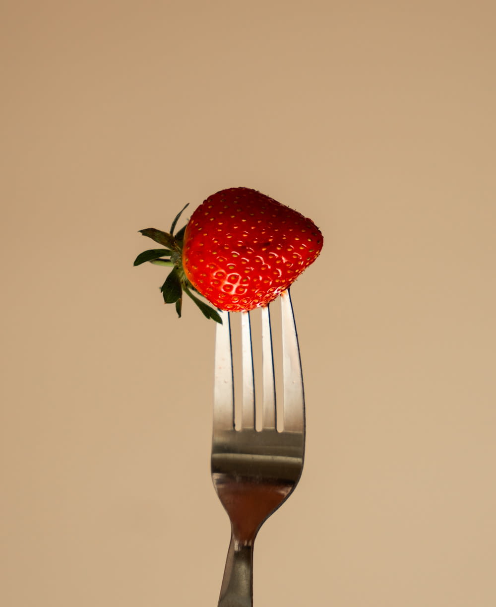 a fork with a strawberry on top of it