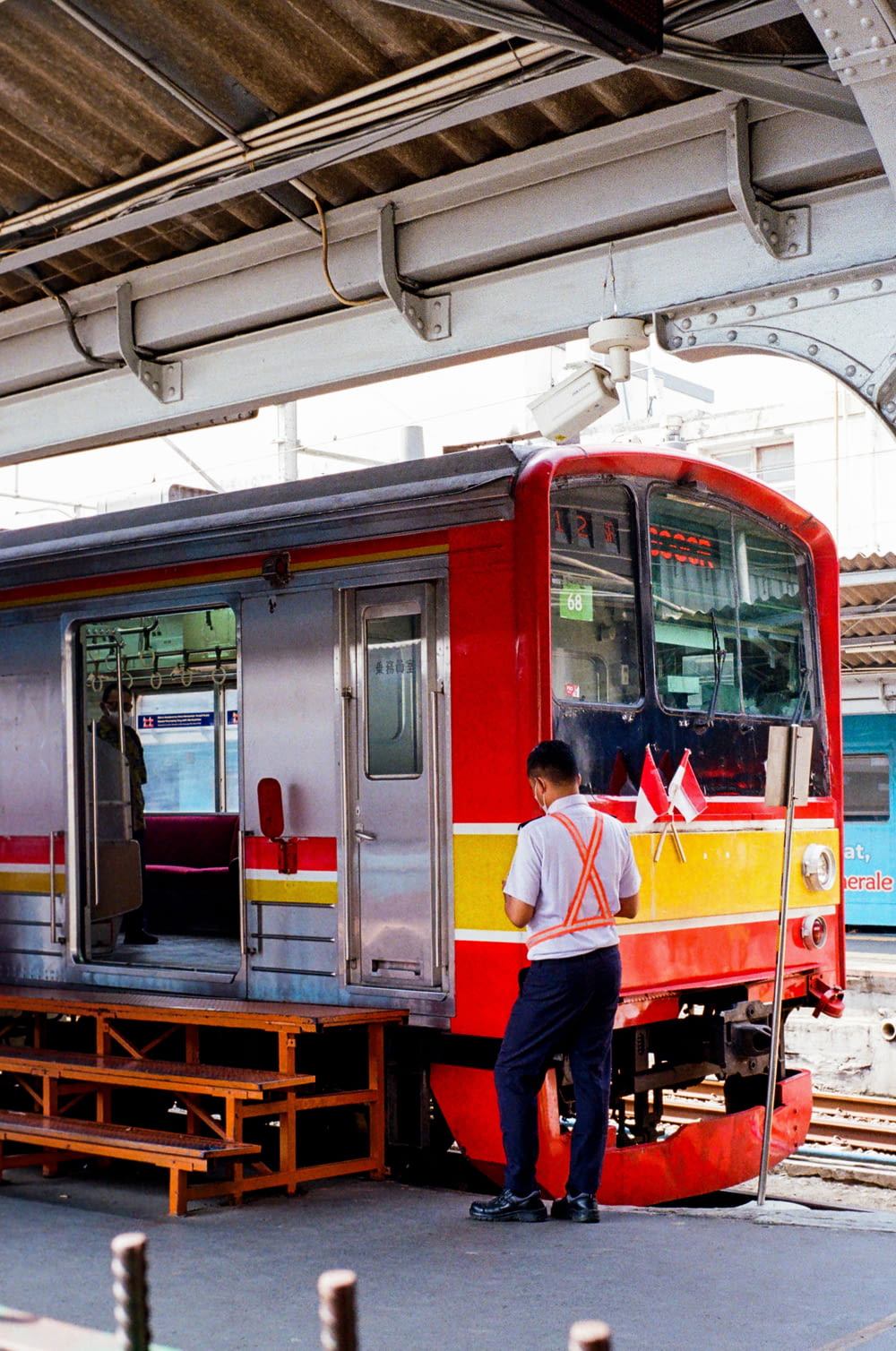 a man standing next to a red and yellow train