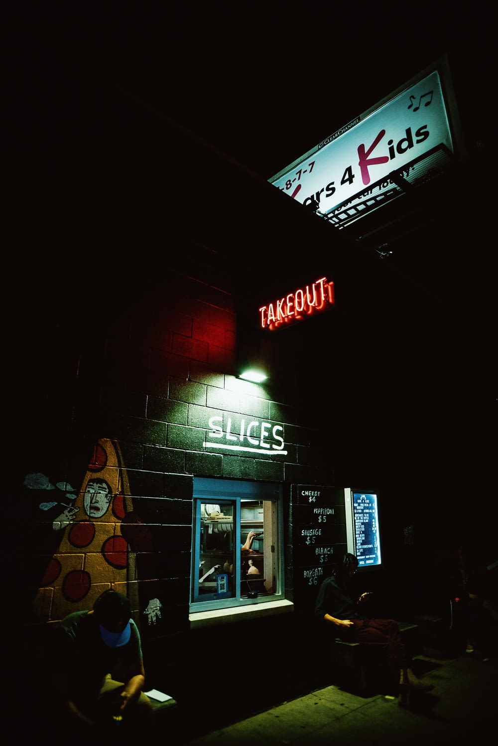 a pizza hut with a neon sign above it