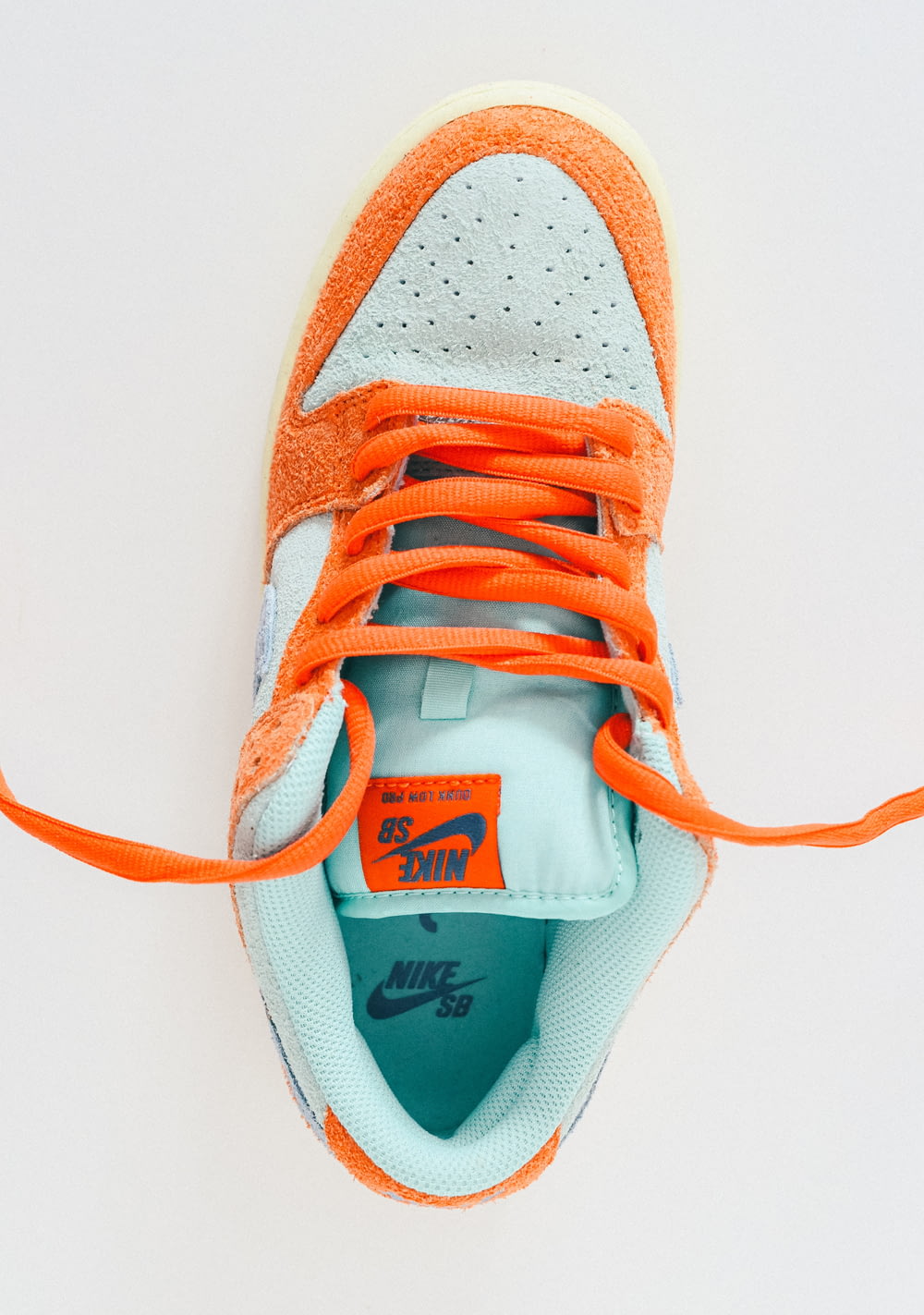 a pair of orange and blue sneakers on a white surface