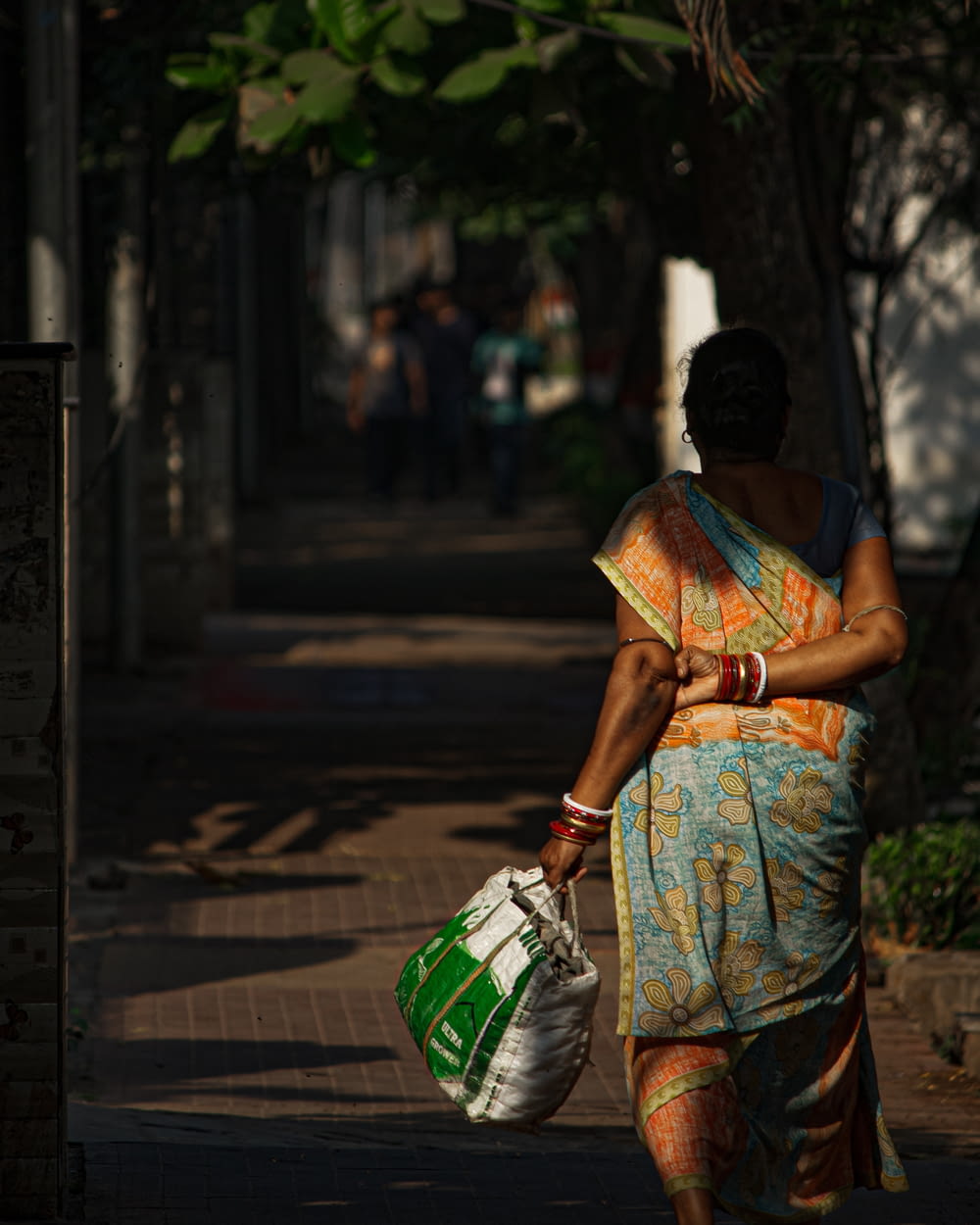 a woman walking down a street carrying a bag