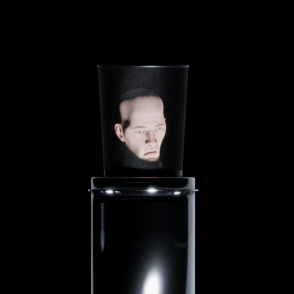 a man's face is reflected in a black container