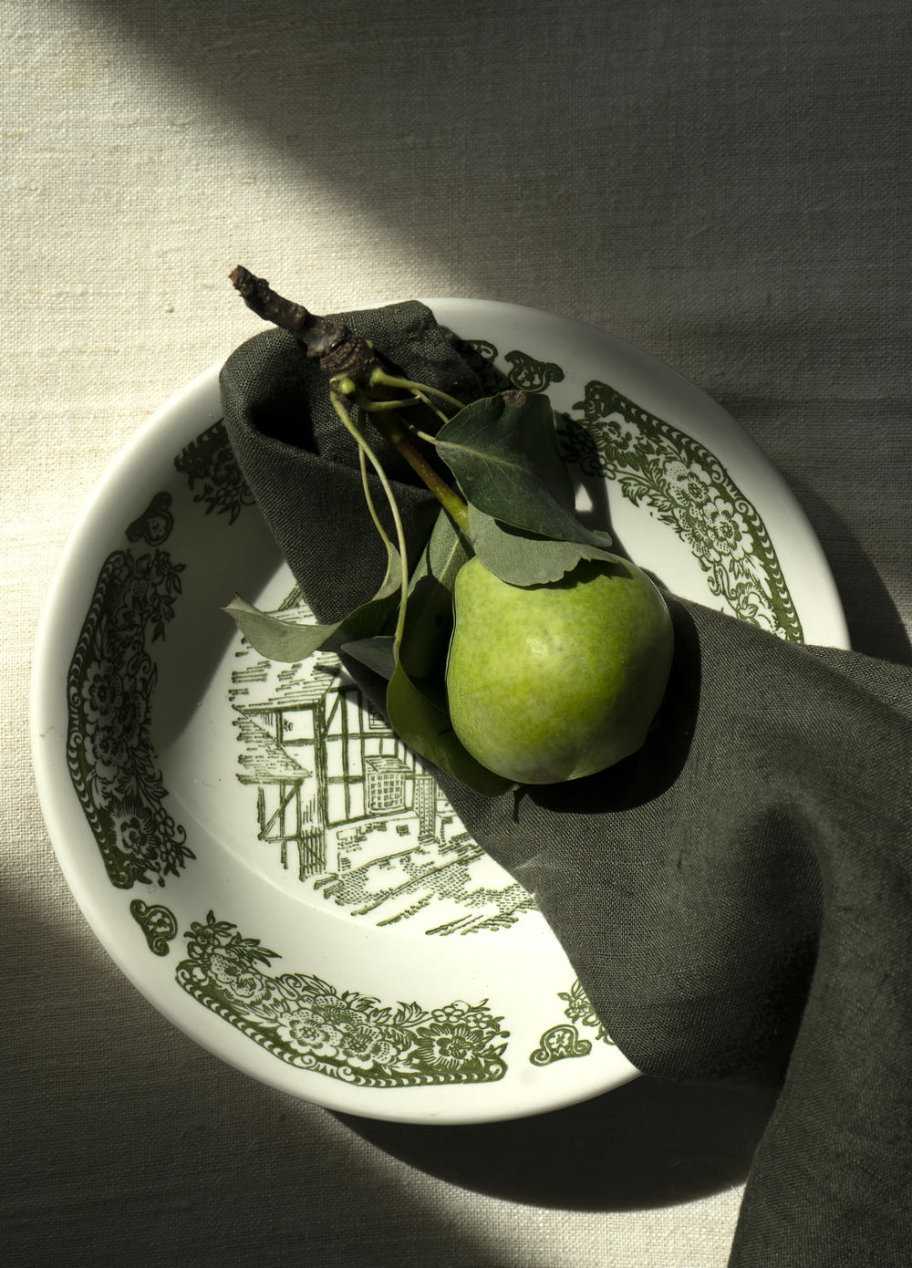 a green apple sitting on top of a white plate