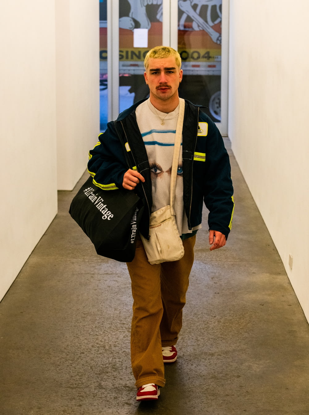 Un uomo che cammina lungo un corridoio portando una borsa