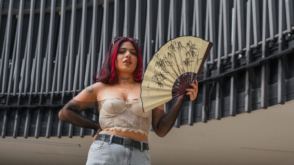 a woman with red hair holding a fan
