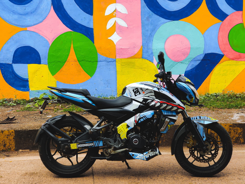 a motorcycle parked in front of a colorful wall