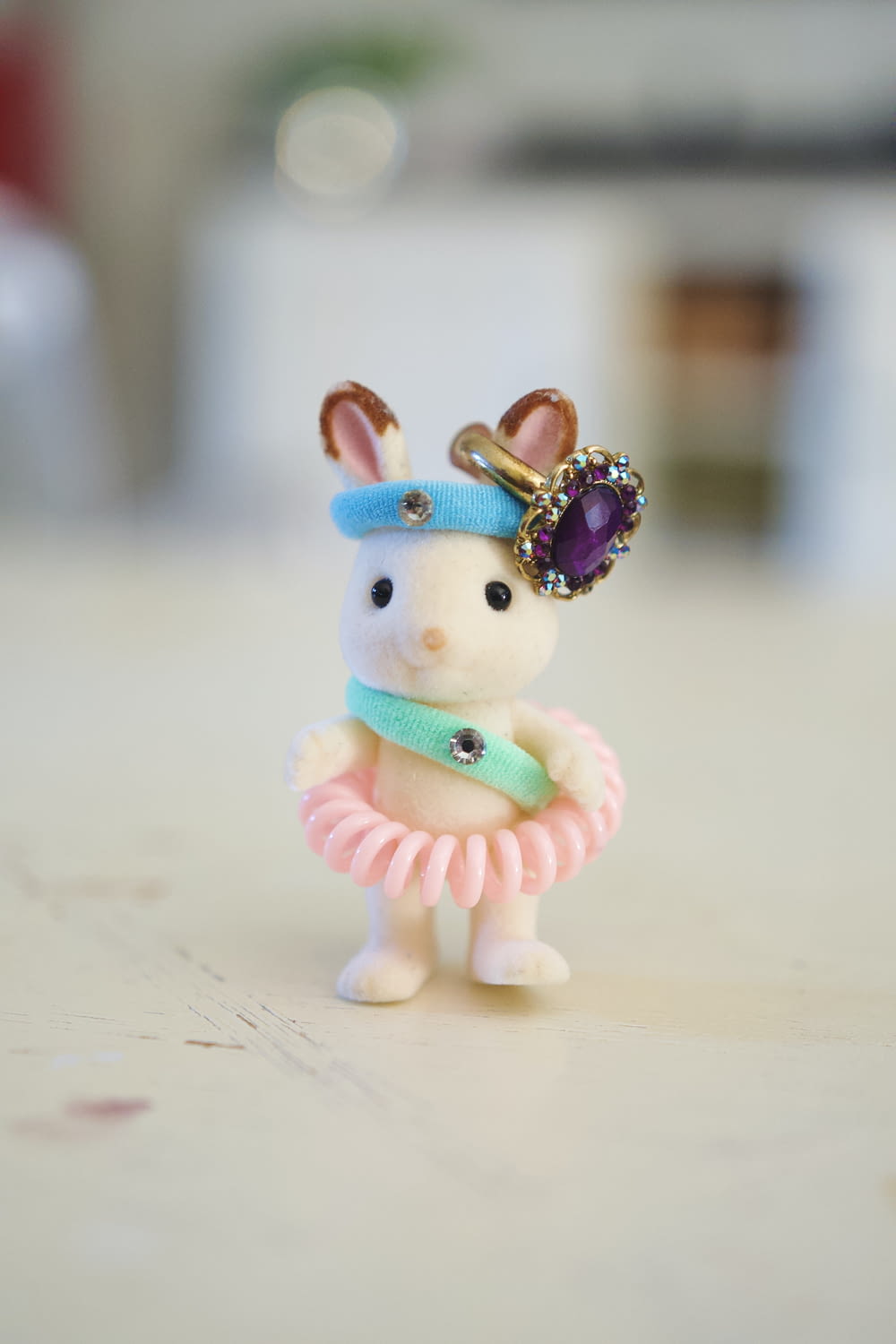 um pequeno coelho de brinquedo usando um vestido e uma tiara