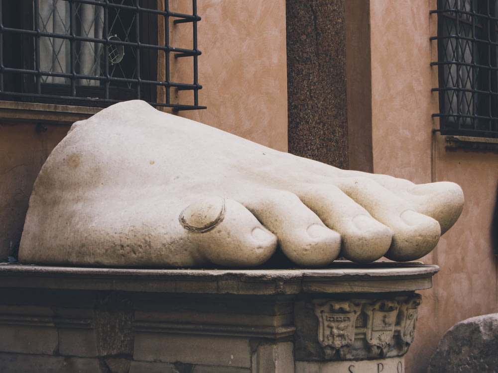 a statue of a foot resting on a ledge