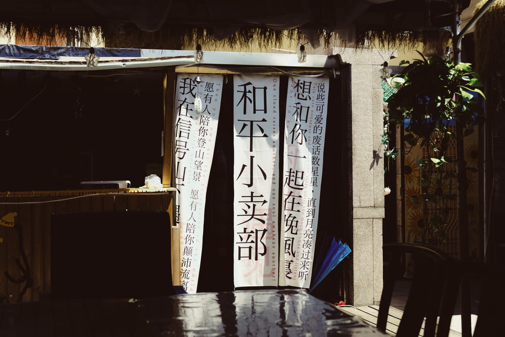 a wooden table sitting in front of a building with asian writing on it