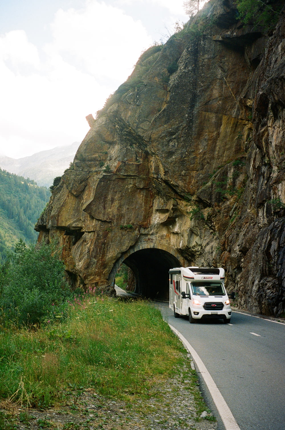 a truck driving into a tunnel on the side of a mountain