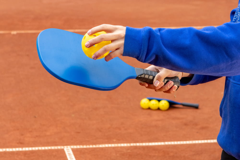 a person holding a tennis racquet on a tennis court