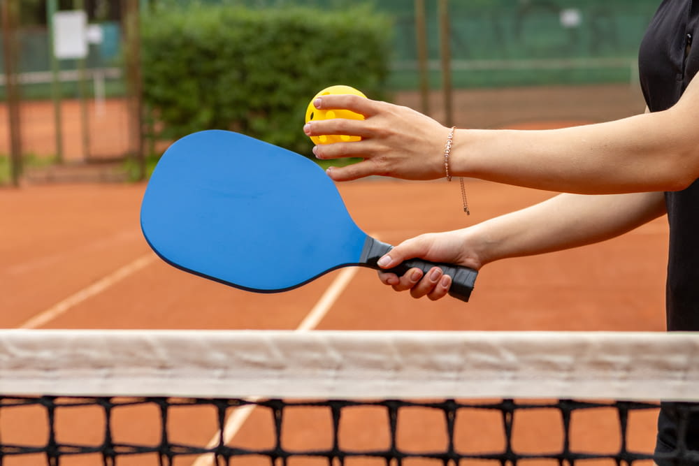 a person holding a tennis racket and a ball