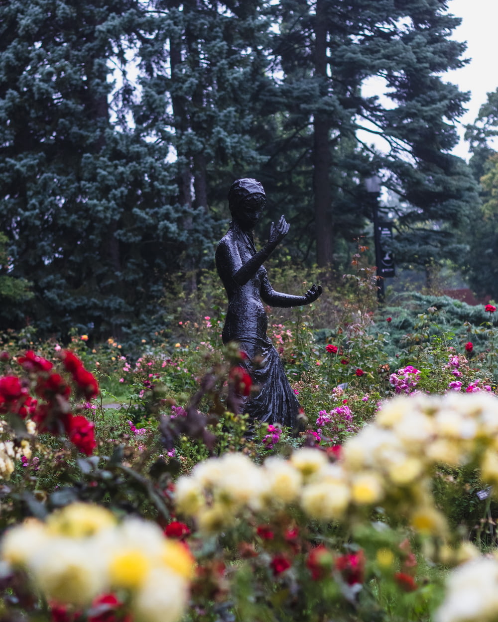 a statue of a woman in a field of flowers