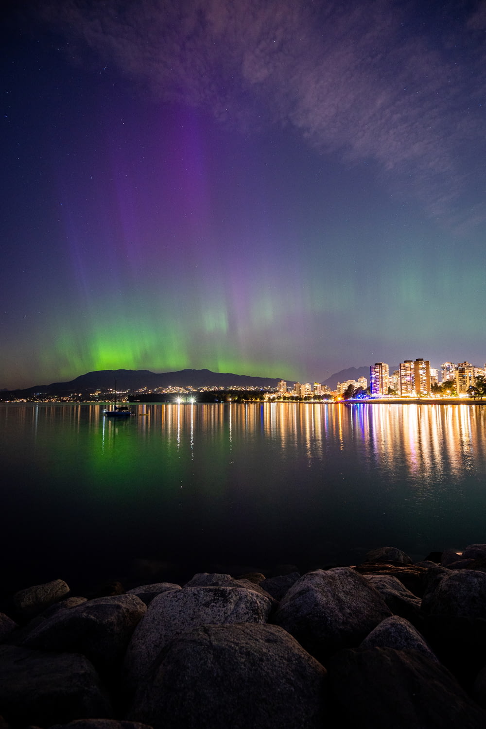 an aurora bore over a city and a body of water