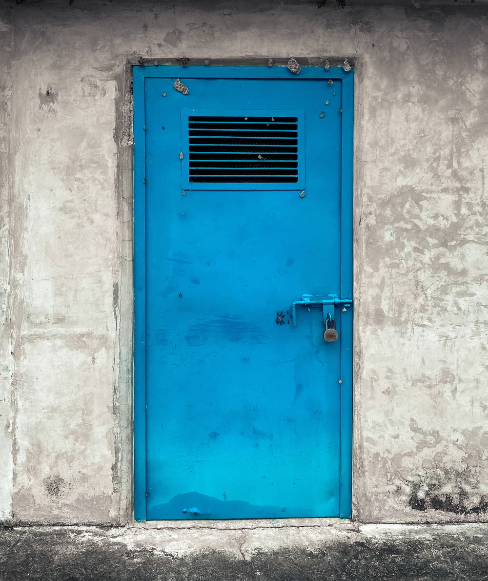 a blue door with a window on a wall