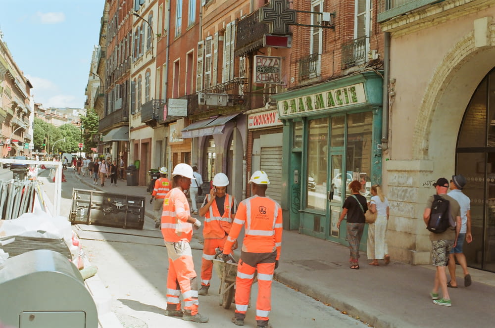 a group of construction workers standing on the side of a road