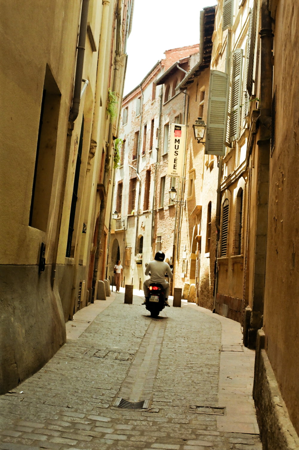 a motor scooter is parked on a narrow street