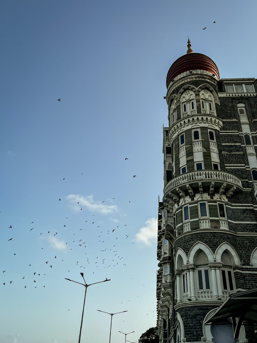 a very tall building with a lot of birds flying around it